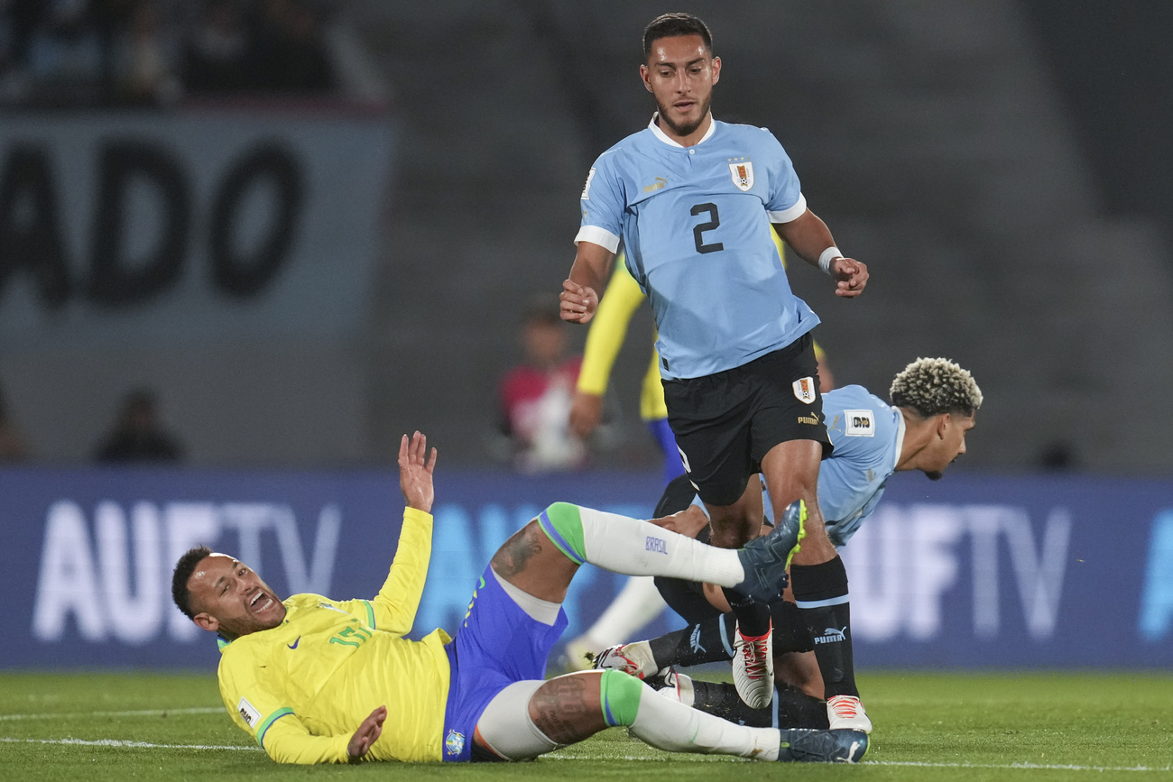 Neymar cai ao disputar a bola com o uruguaio Sebastián Cáceres durante uma partida das eliminatórias para a Copa do Mundo da FIFA 2026 no Estádio Centenário, em Montevidéu, Uruguai, na terça-feira, 17 de outubro de 2023.