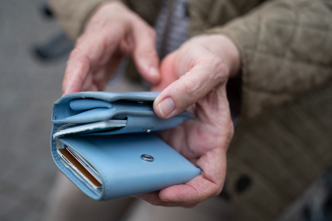 Ein älterer Mensch hält ein Portemonnaie in der Hand