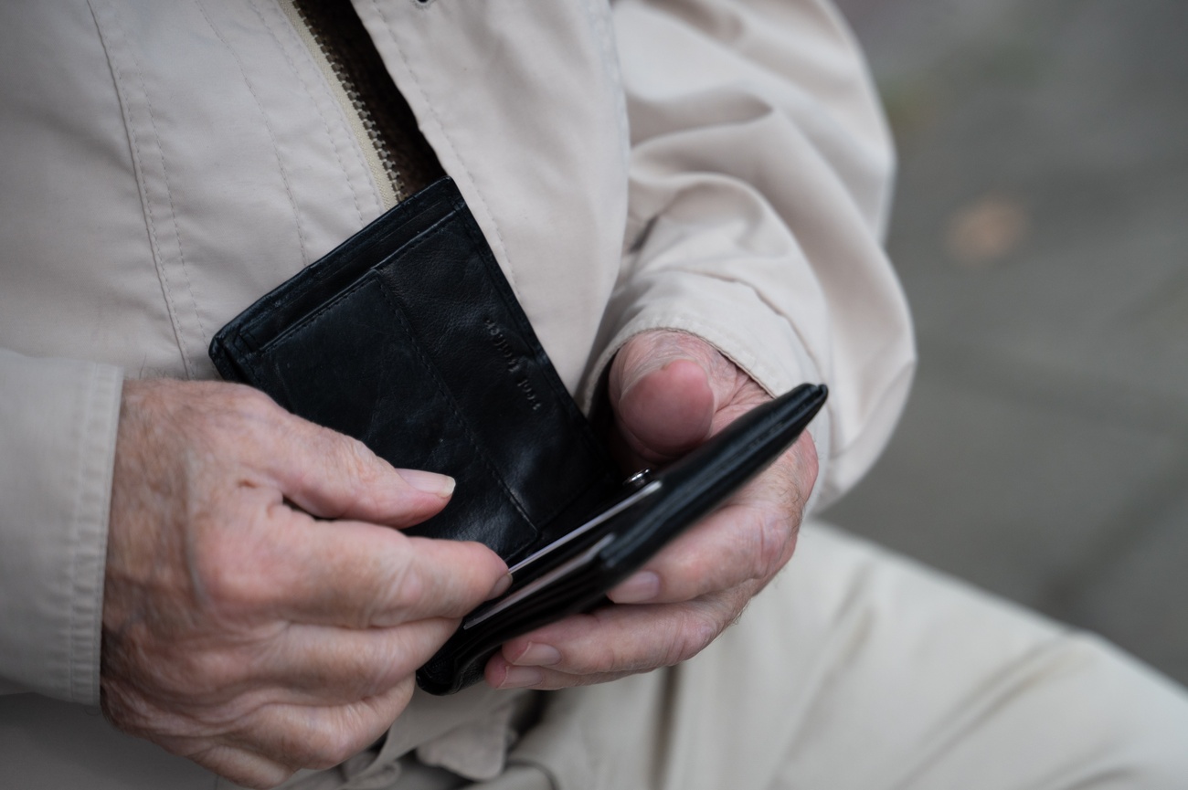 persona anziana controlla il proprio portafogli