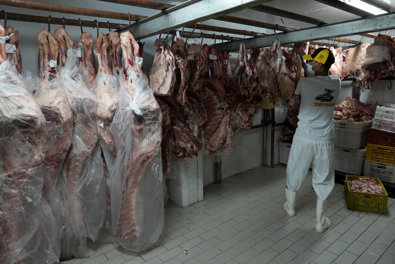 Açougueiro pendurando carnes