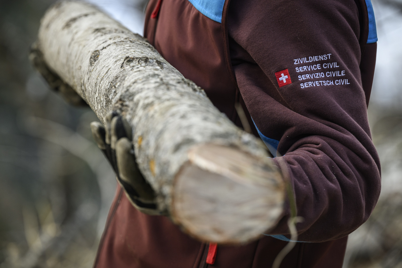 un homme porte une bûche de bois