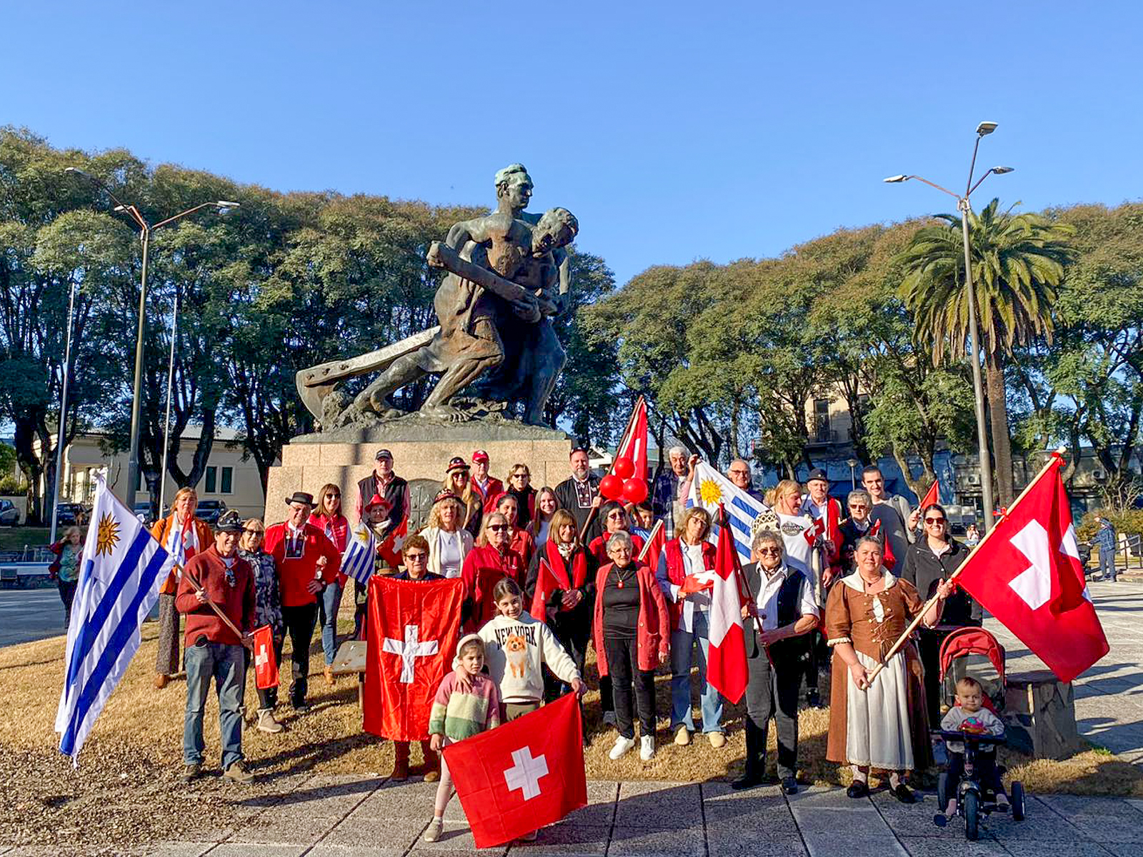 A group of people carrying Swiss flags and an Argentine flag