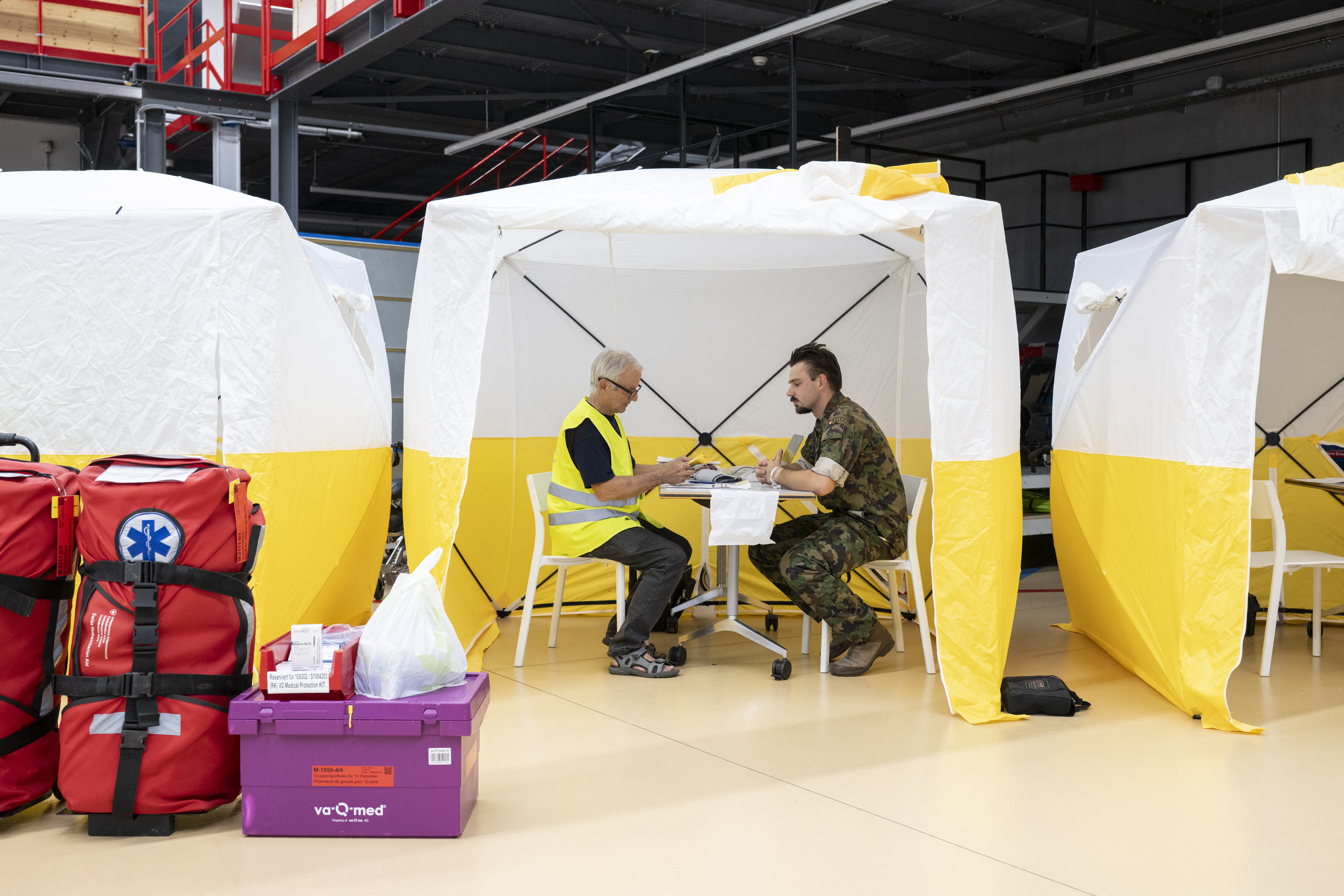 due soccorritori discutono a un tavolo sotto un gazebo