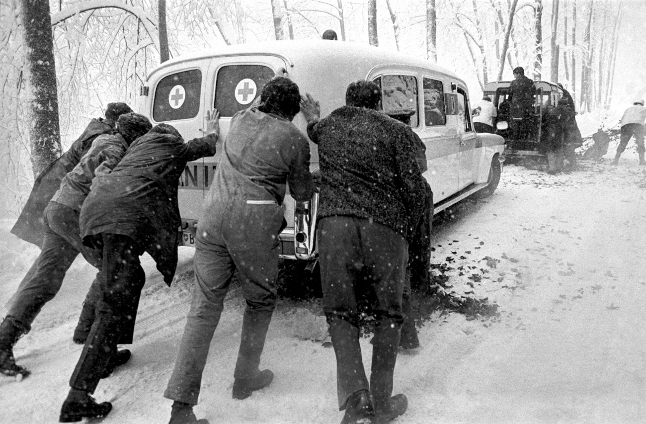 Persone spingono un ambulanza, vecchia foto in bianco e nero