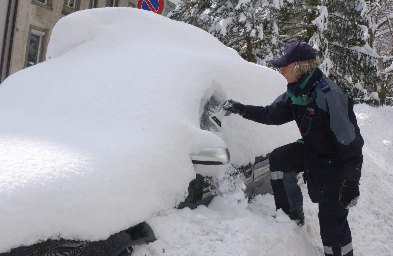 毫不留情。一名瑞士女交警正在雪裡翻找停車證證明。