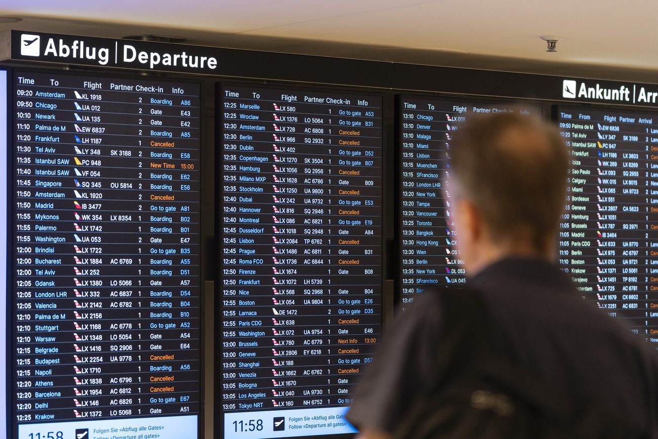 persona davanti a pannello partenze di un aeroporto