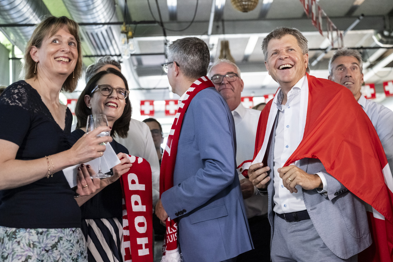 Nationalraetin Celine Weber, GLP-VD, das Co Praesidium der FDP, Nationalraetin Susanne Vincenz-Stauffacher, FDP-SG, und Staenderat Benjamin Muehlemann, FDP-GL, Christoph Maeder, Praesident von economiesuisse, Nationalrat Juerg Grossen, GLP-BE, in eine Schweizer Fahne gehuellt, und Severin Moser, Praesident des Schweizerischen Arbeitgeberverbands, von links, freuen sich am Abstimmungsstamm einer ueberparteilichen Allianz gegen die Volksinitiative "Keine 10-Millionen Schweiz -Nachhaltigkeitsinitiative" der SVP, ueber die Volk und Staende an diesem Abstimmungssonntag befanden, am Sonntag, 14. Juni 2026 in Bern. Die Hochrechnungen haben soeben eine deutliche Ablehnung der Initiative vorausgesagt.