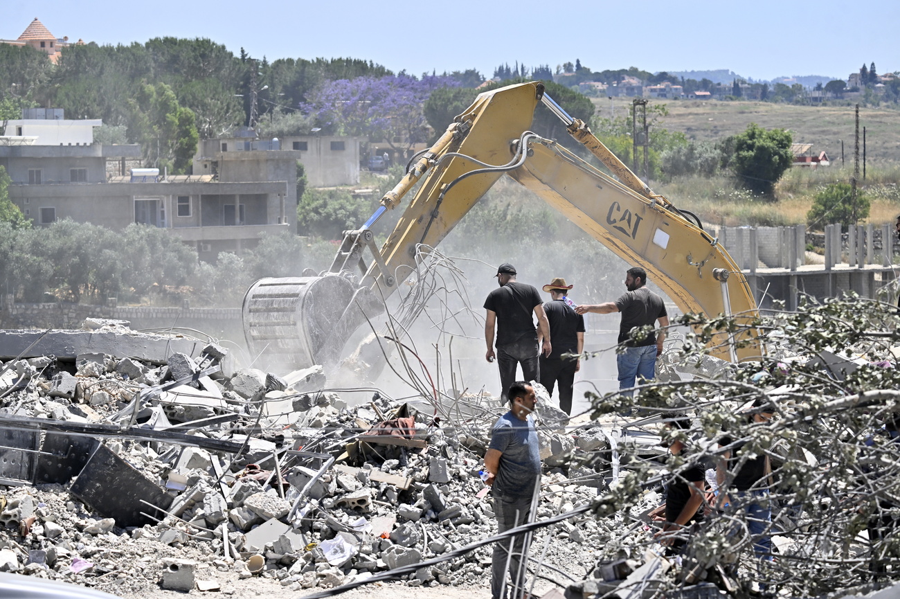 سكان عائدون يبحثون عن مفقودين تحت أنقاض مبنى مدمّر في بلدة تولين، جنوبي لبنان، بعد إعلان إطار أولي لإنهاء الأعمال العسكرية في المنطقة.