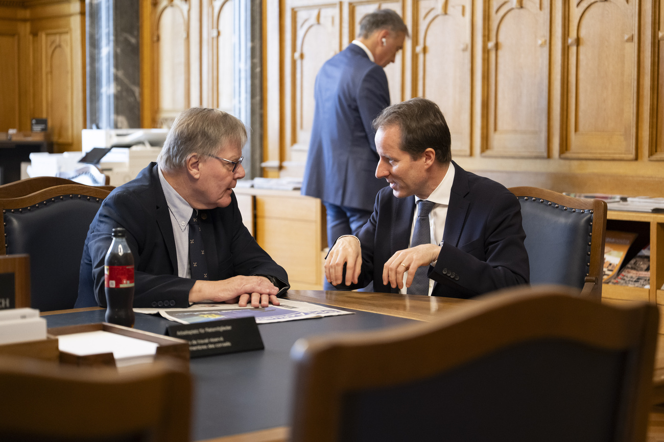 il capogruppo dell’UDC Thomas Aeschi discute attorno a un tavolo con Thomas Sormanni del MCG di Ginevra.