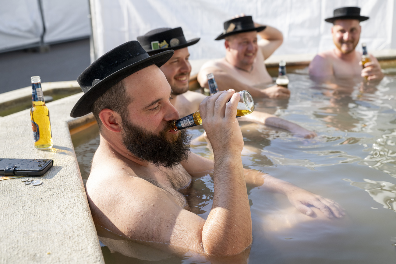 des hommes qui boivent une bière assis dans une fontaine