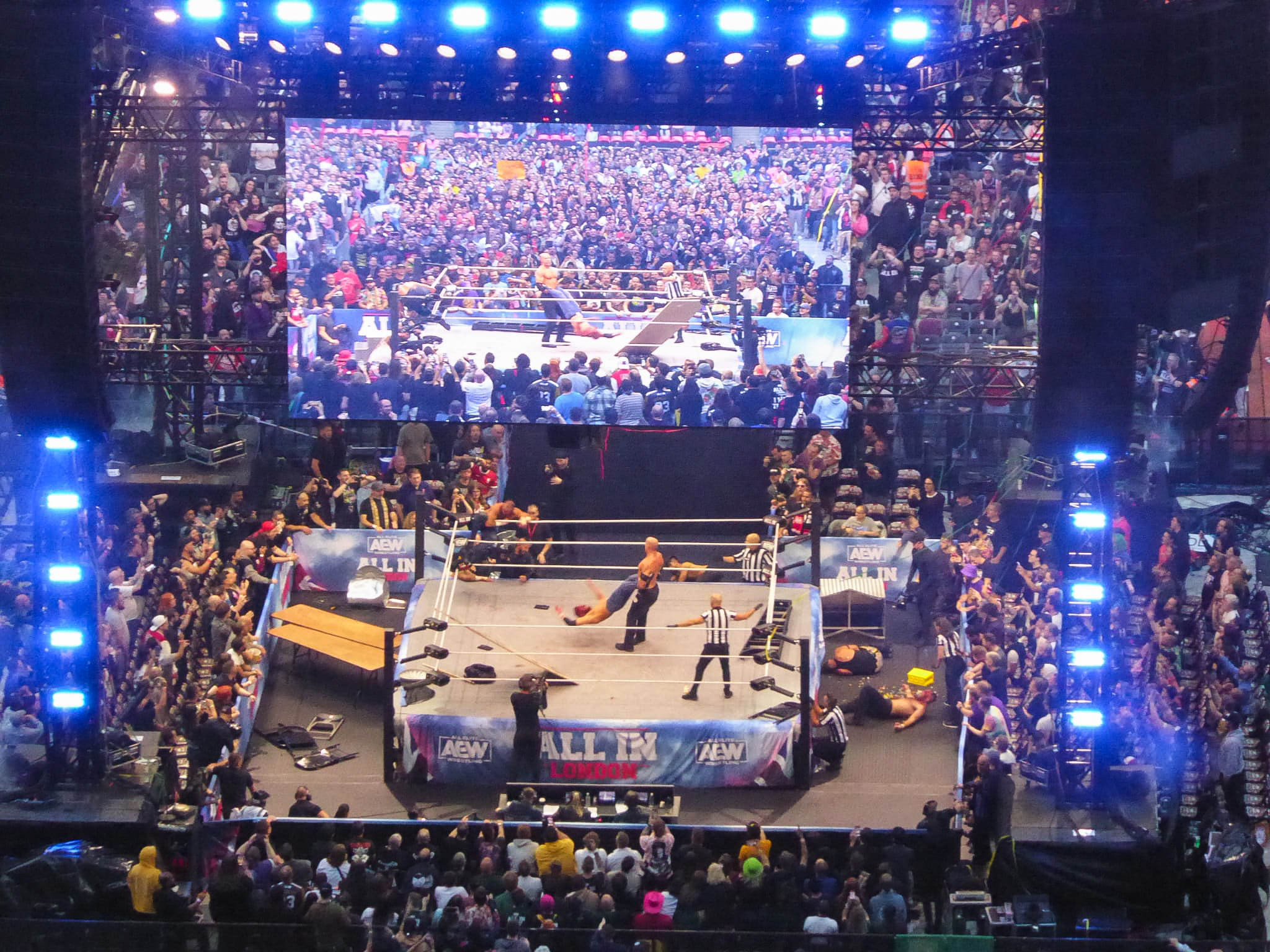 Blick in eine Halle voller Menschen, in der Mitte ein Wrestling-Ring
