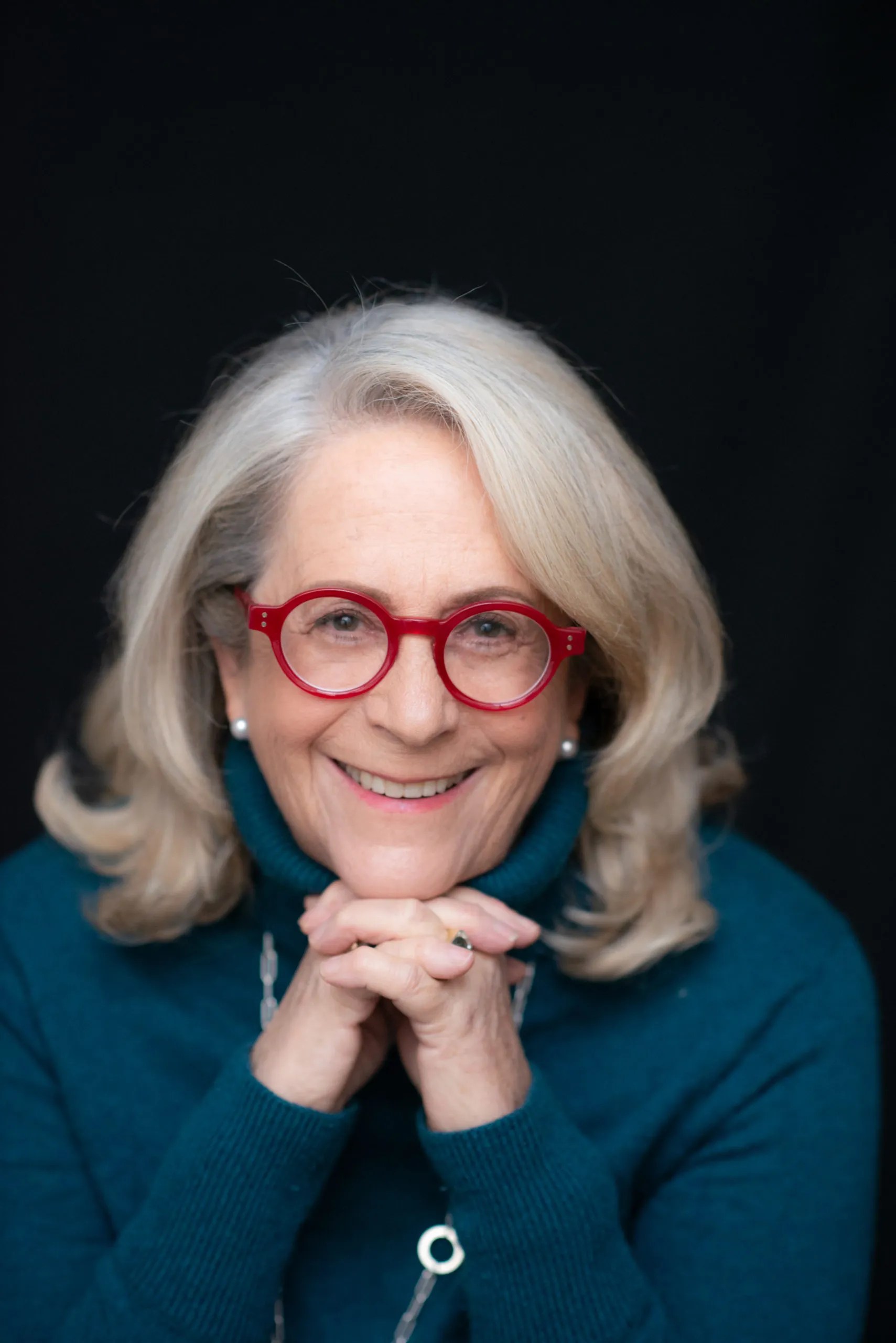 une femme de 70 ans aux lunettes rouges