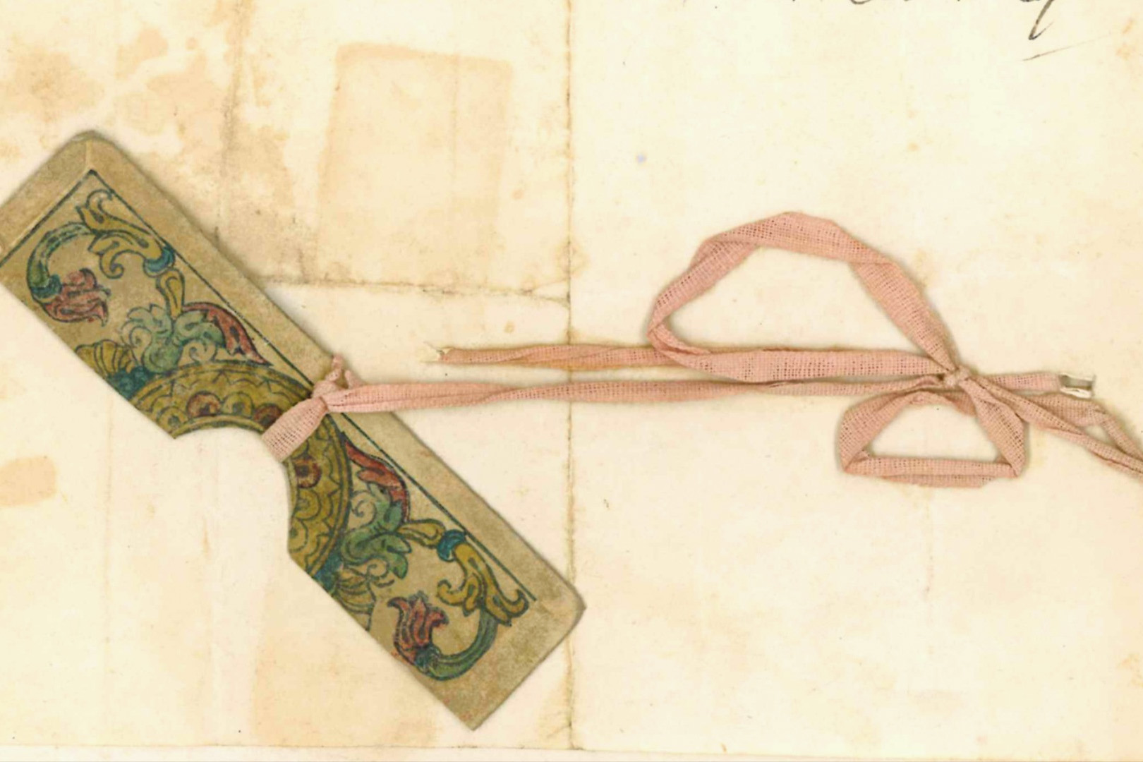 Metà di una carta da gioco colorata con un nastro rosa.
