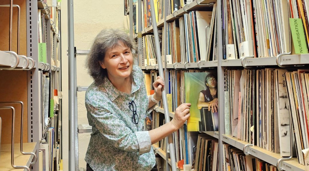 Eine Frau greift in ein Gestell voller Schalllatten