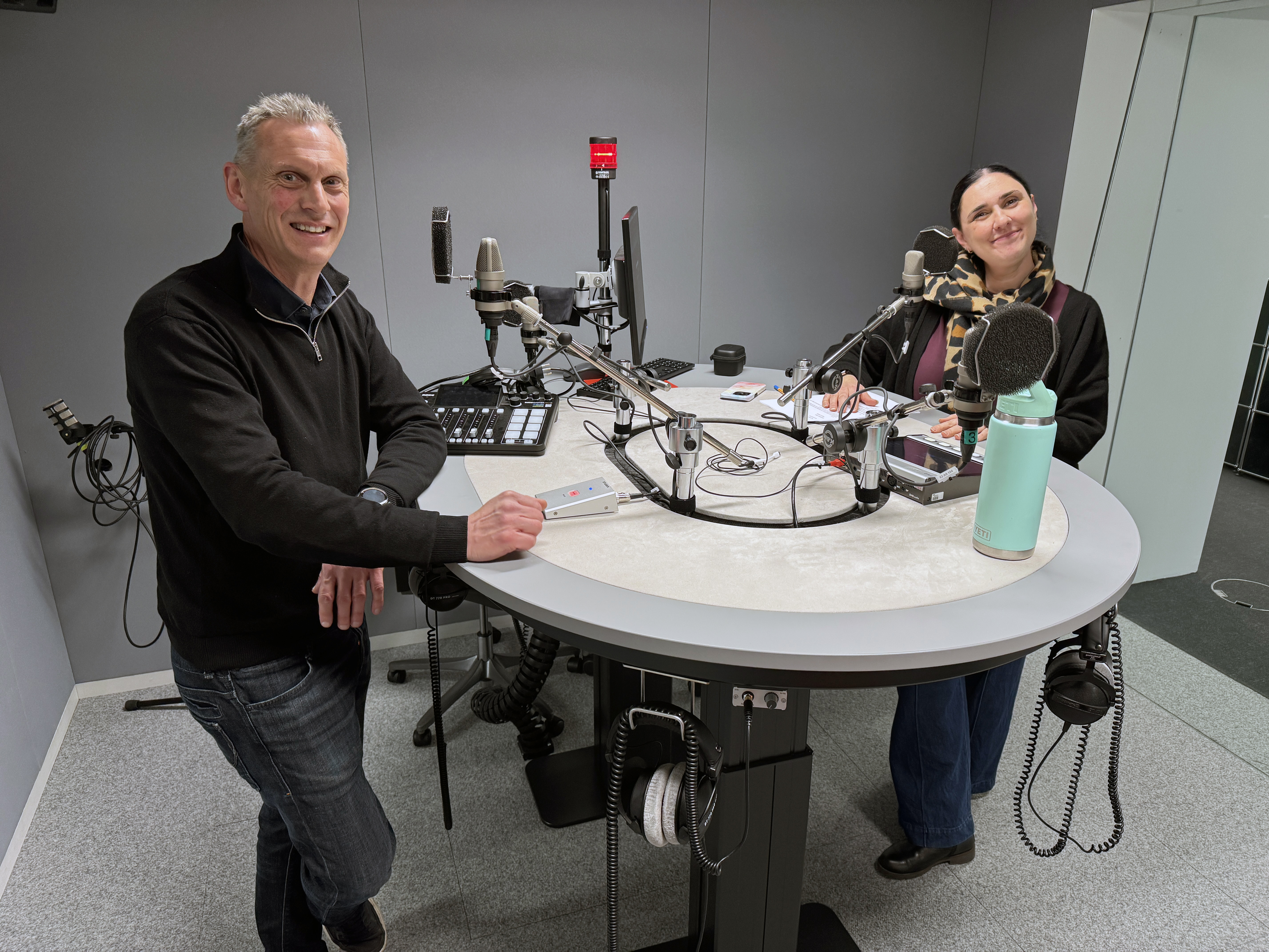 Journalists in a podcast studio.