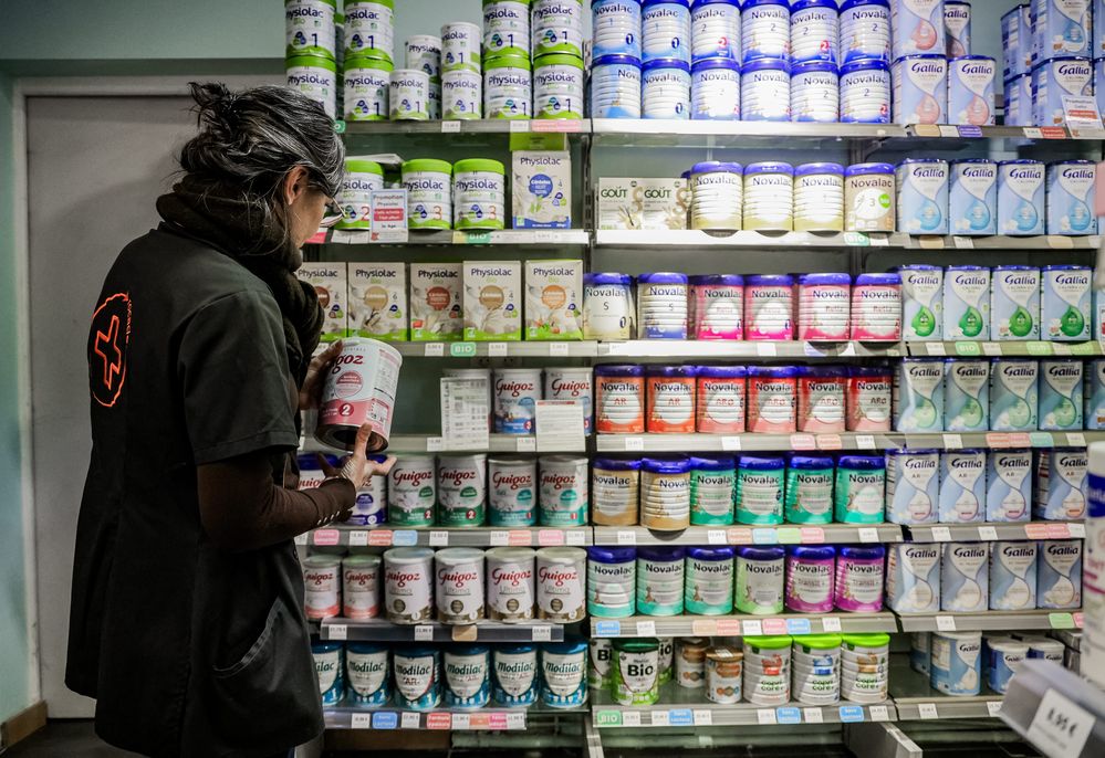 Woman standing in front of a shelf stocked with baby formula