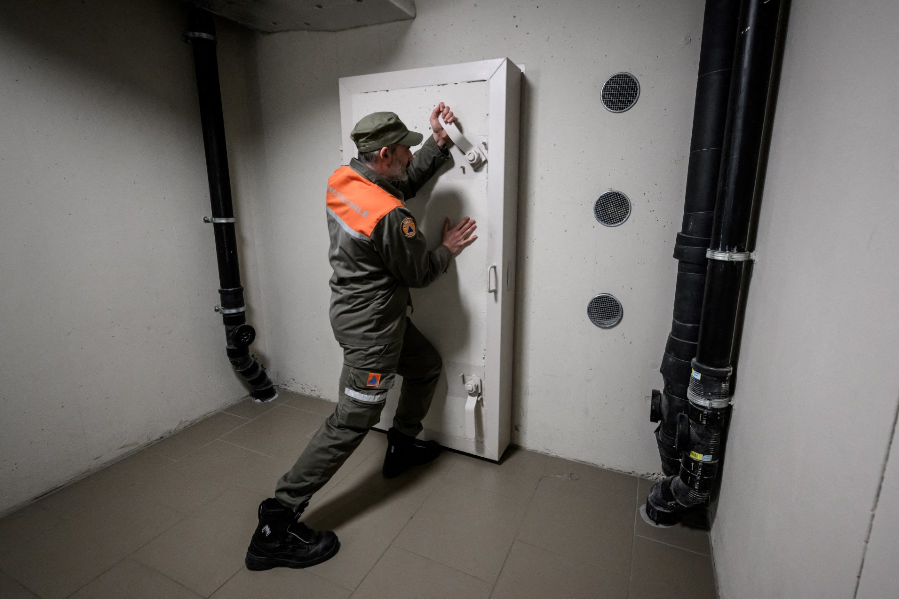 A community service worker closes the door to a civil defence shelter in Switzerland