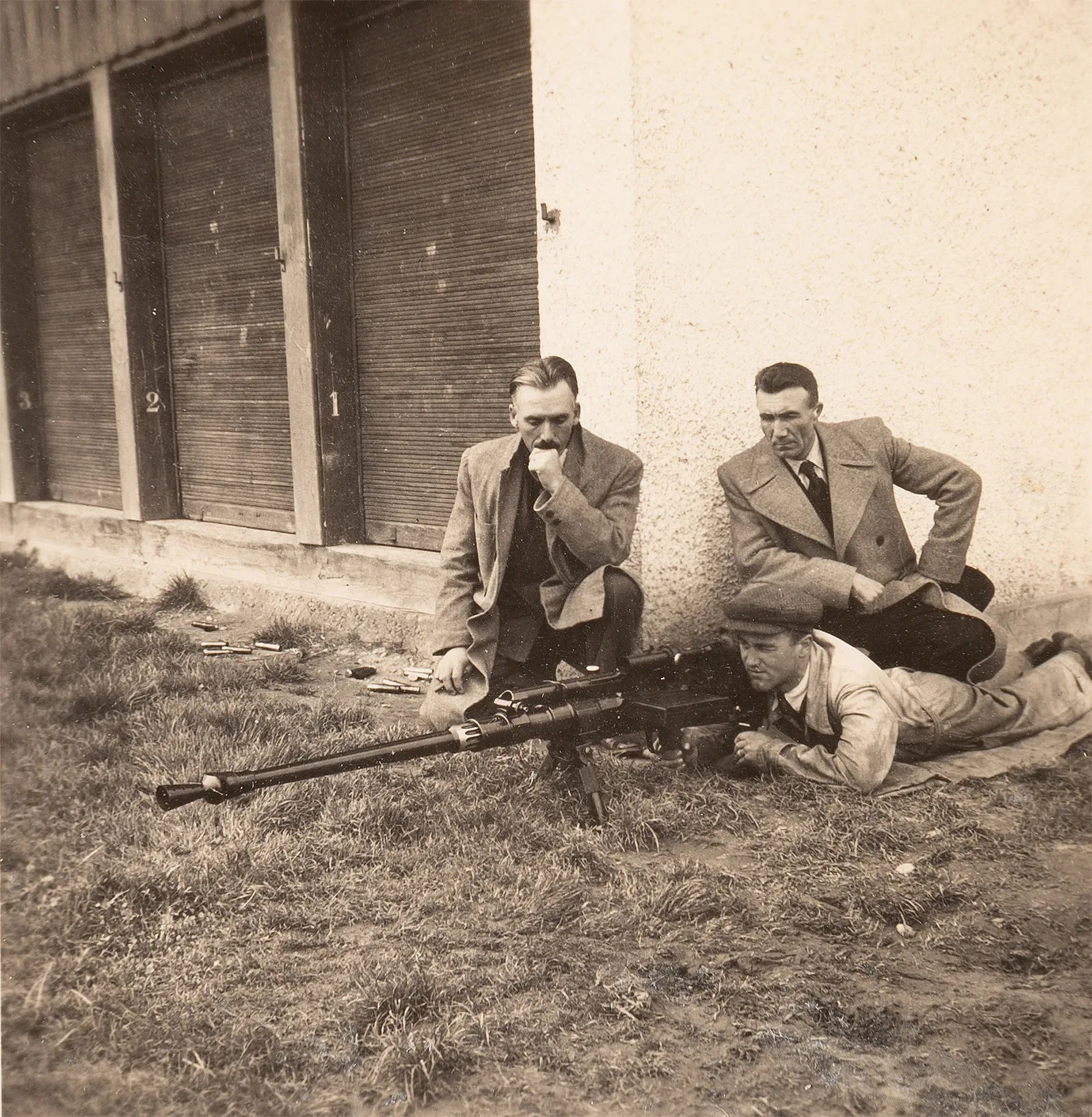 Ein Schütze und zwei Ingenieure um eine alte Panzerabwehrwaffe herum
