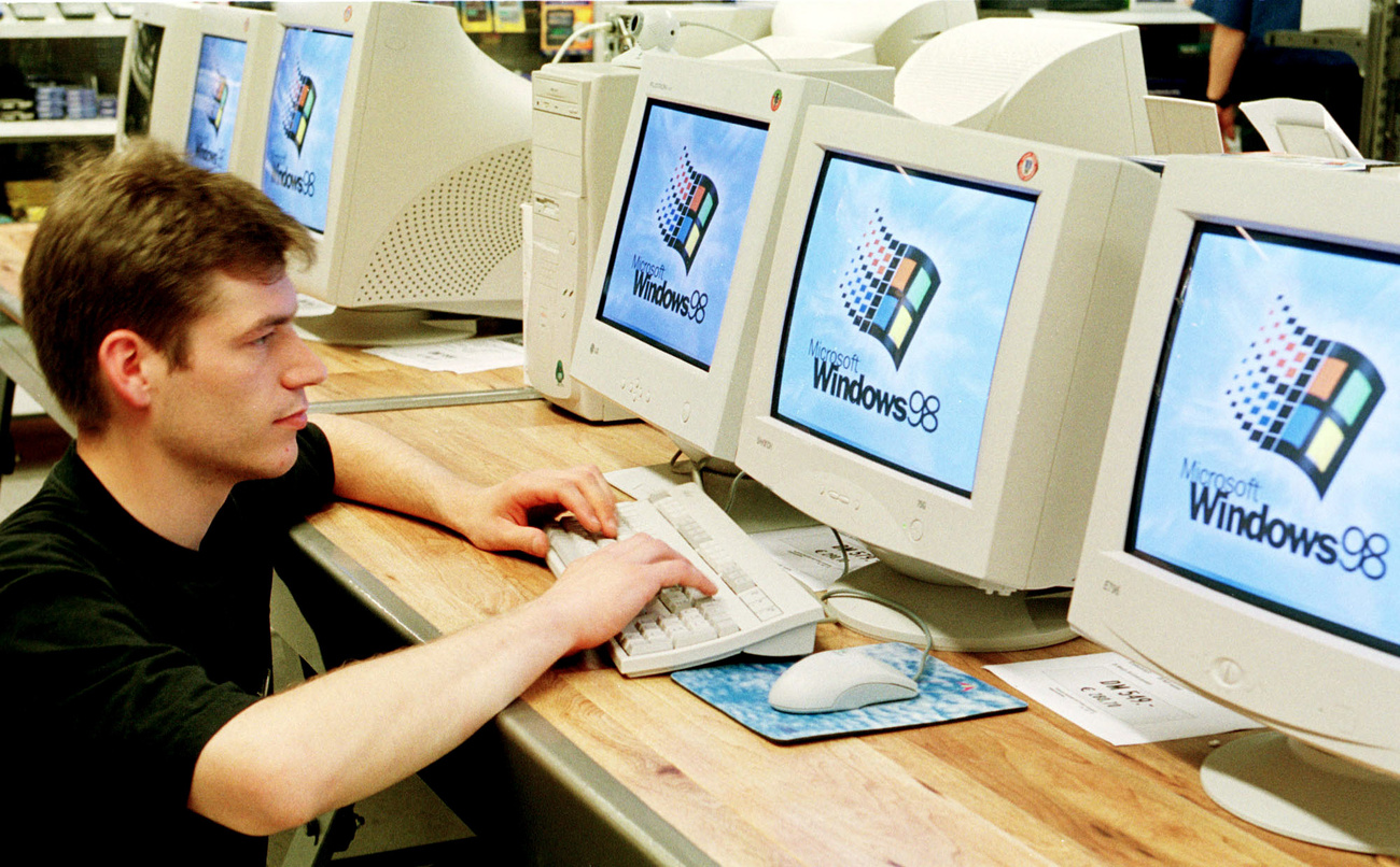 Persona davanti a fila di computer usa Microsoft Windows
