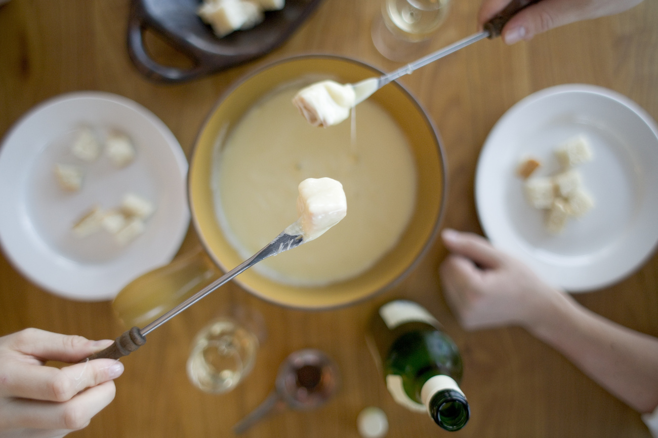 Deux fourchettes au dessus d'un caquelon à fondue