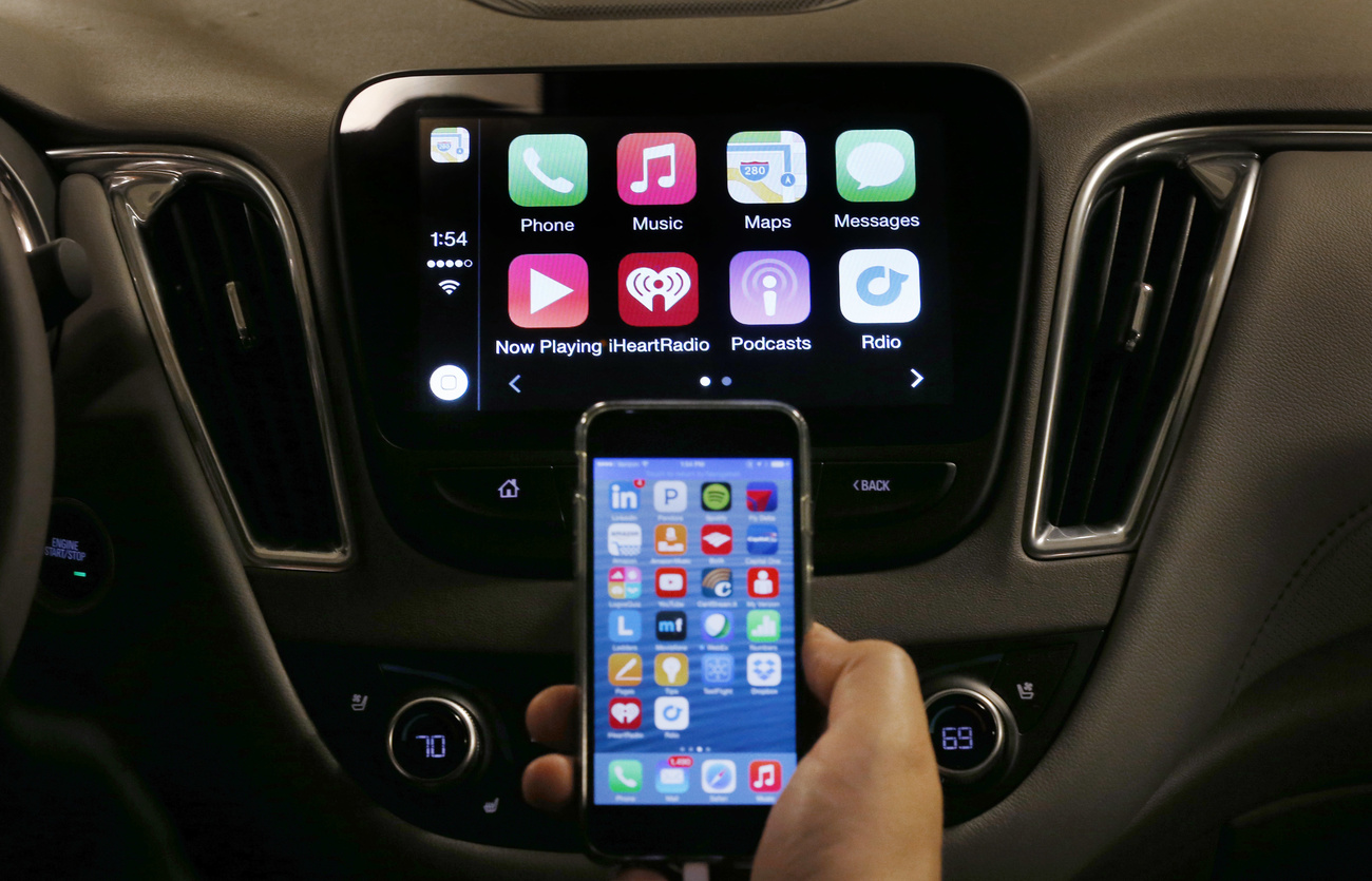 An iPhone is connected to a 2016 Chevrolet Malibu equipped with Apple CarPlay apps, displayed on the car's MyLink screen, top, during a demonstration in Detroit, Tuesday, May 26, 2015. Starting with Chevrolet this summer, many General Motors models will offer AppleâÄ™s CarPlay and GoogleâÄ™s Android Auto systems that link smart phones with in-car screens and electronics. (AP Photo/Paul Sancya)