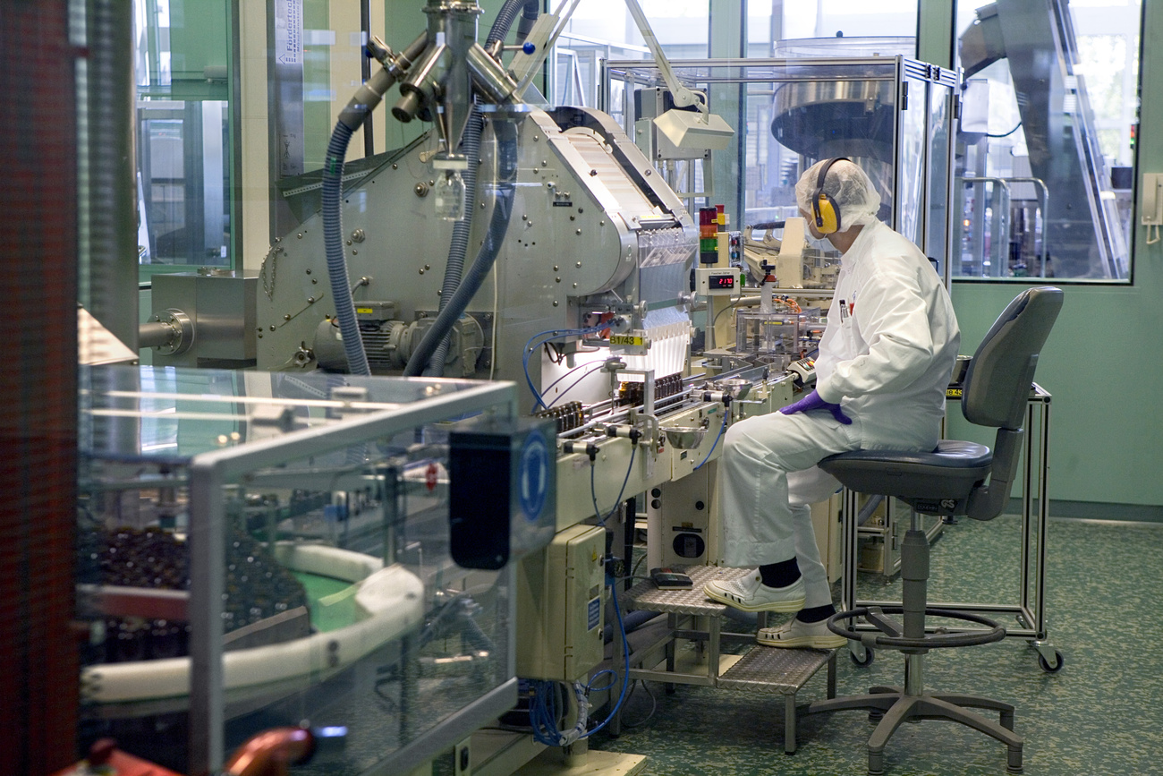 lavoratore roche in tuta e maschera controlla un macchinario