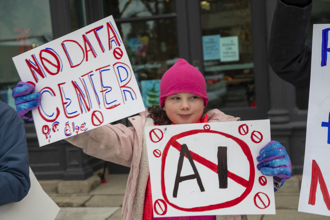 a child holding protest signs against a data centre
