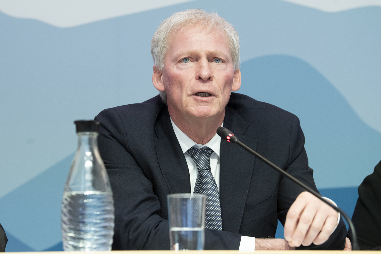 Ein älterer Mann im Anzug spricht an einem Rednerpult in ein Mikrofon