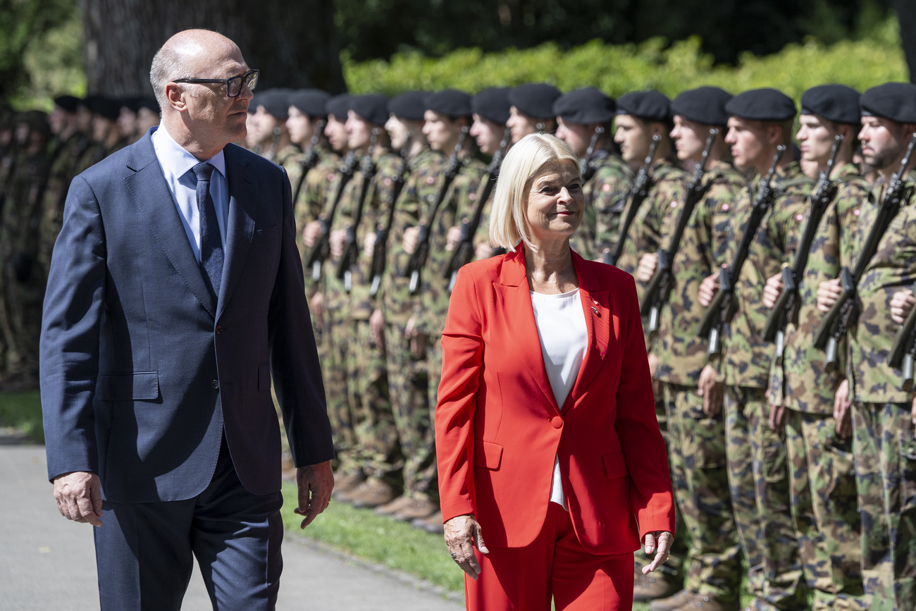 Ein MAnn und eine Frau schreiten eine militärische Ehrenparade ab