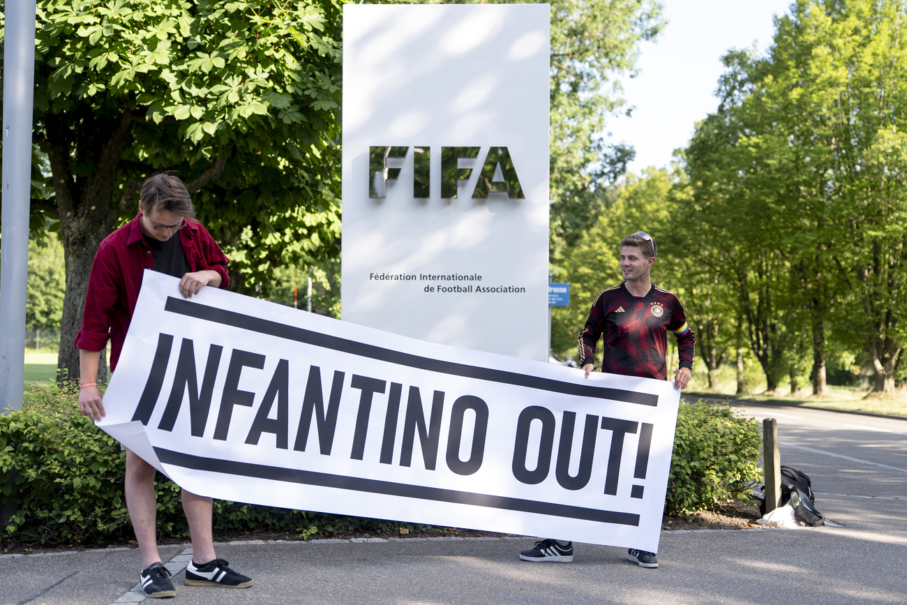 Zwei Fussballfans demonstrieren vor dem Fifa-Hauptsitz mit einem Transparent "Infantino Out"
