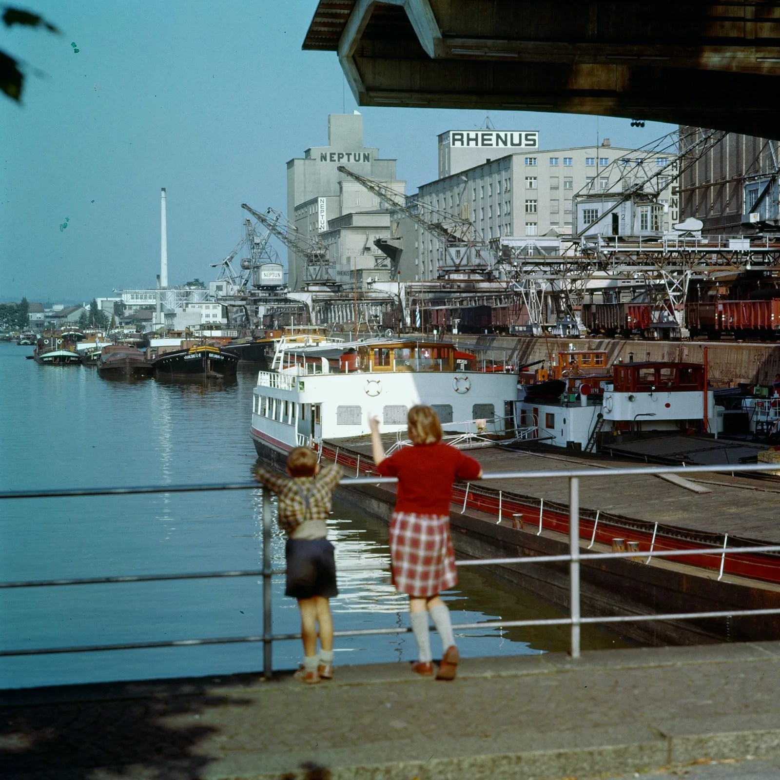 Kinder, die das Treiben in einem Rheinhafen beobachten