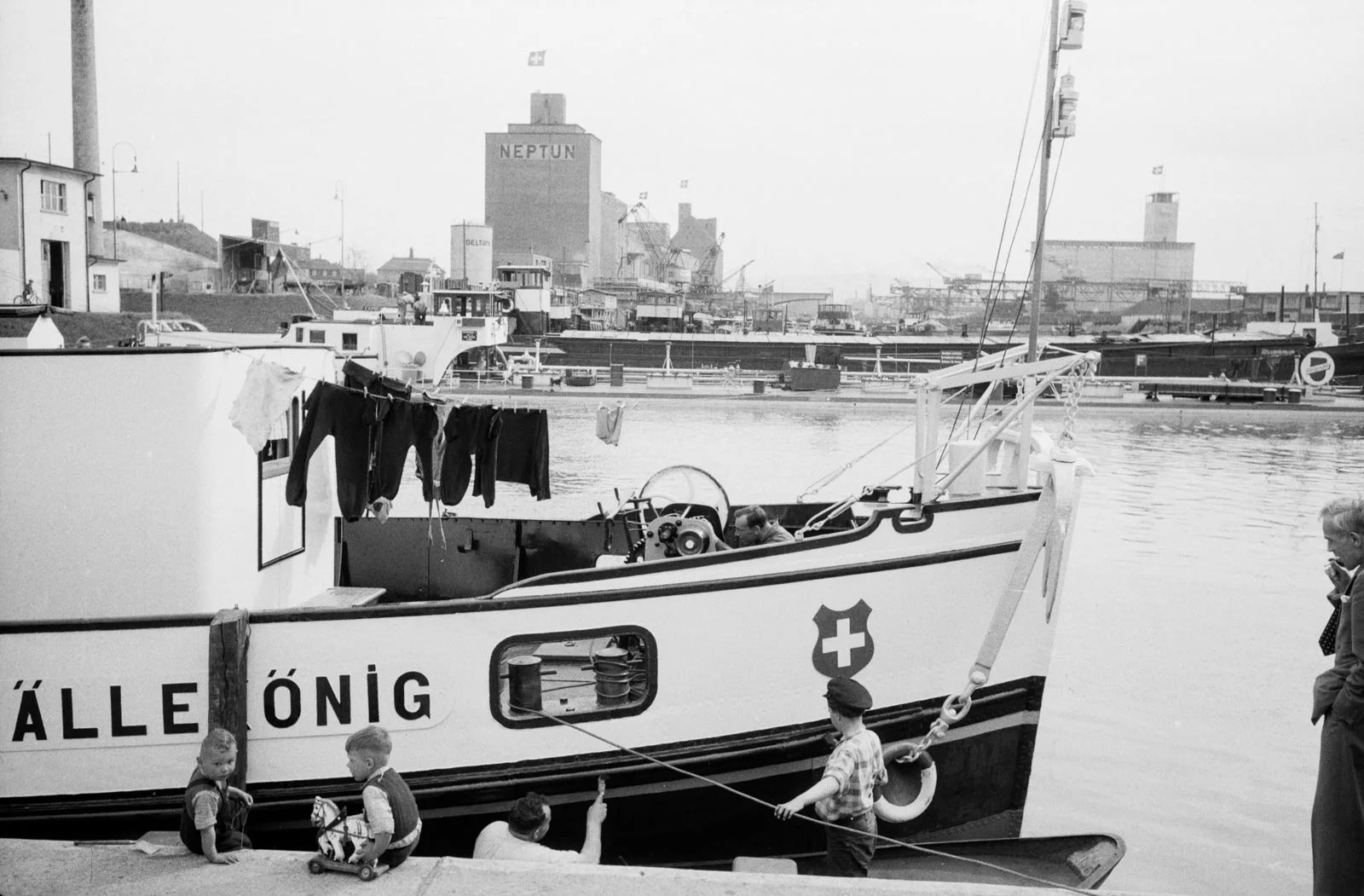 Zwei Kinder neben einem Boot in einem Hafen am Rhein