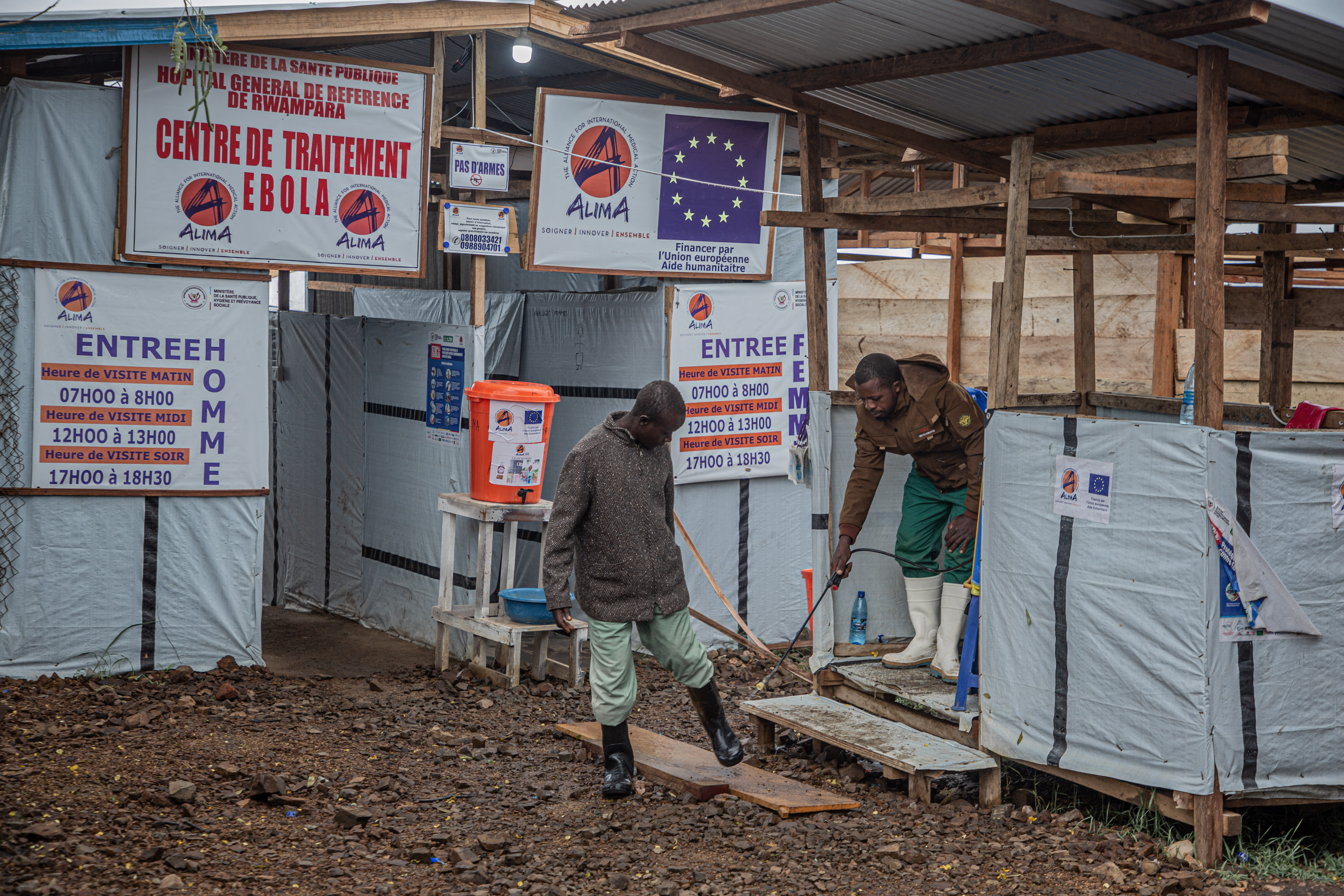 A hygiene worker disinfects a person's feet at the entrance to the Rwampara Ebola Treatment Centre (ETC) in Bunia, Ituri, in the east of the Democratic Republic of Congo on July 13, 2026.