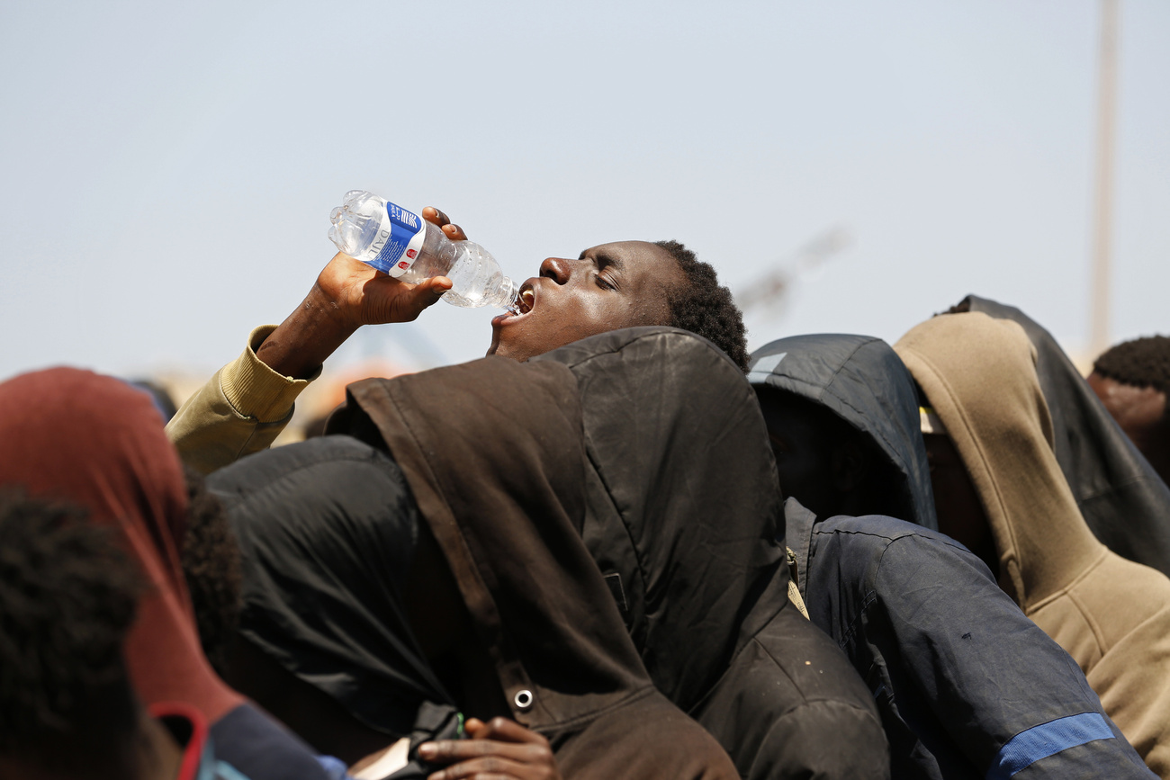 Ein afrikanischer Mann trinkt den letzten Tropfen aus einer Petflasche