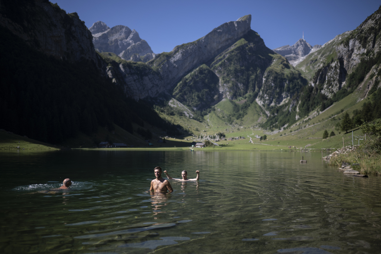 persone fanno il bagno in un laghetto alpino