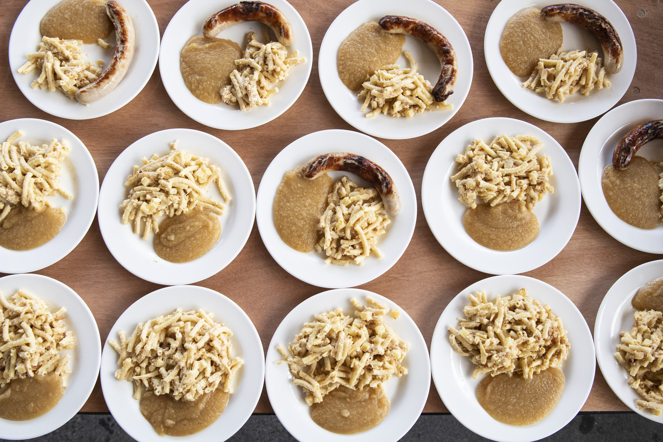 Plates of macaroni, a sausage and mashed apple