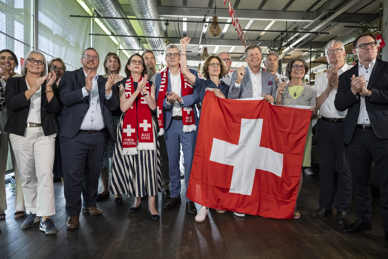 Jubelnde Menschen mit einer Schweizer Flagge
