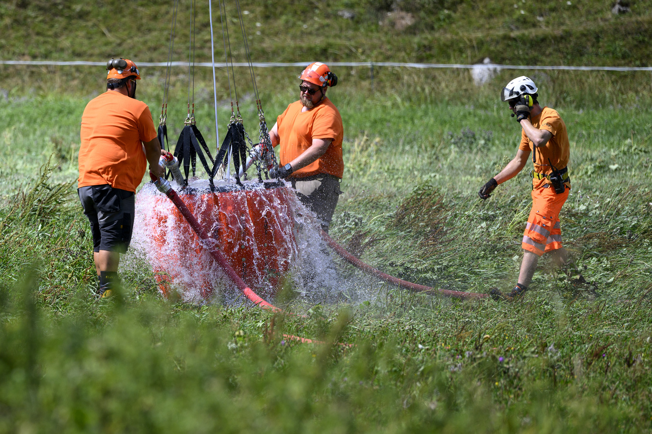 Ein Helikopter fliegt Wasser auf die Freiburger Alpen: Die Situation der Landwirtschaft fordert auch die SVP heraus.