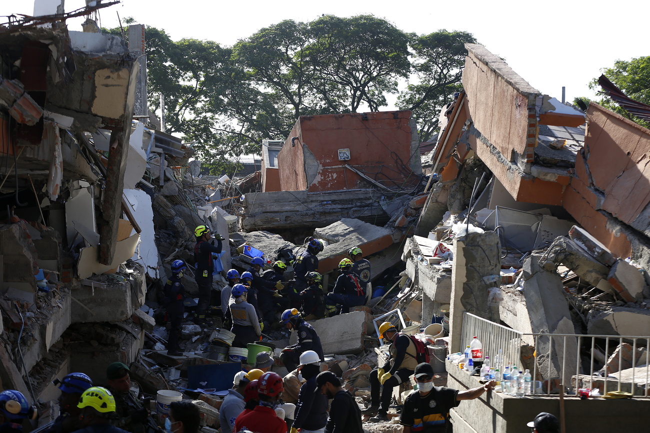 Des secouristes et des particuliers cherchent des victimes sous les déceombres des bâtiments qui se sont effondrés à Cali, Colombie, après le séisme de magnitude 7,4 du 10 août 2026.