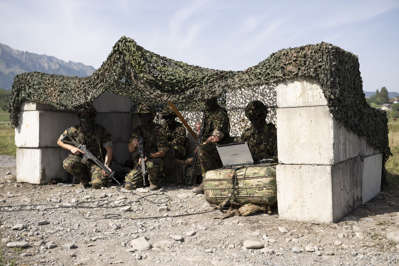 Personale militare e operatori di droni dell’esercito svizzero si riparano durante un evento per i media sull’uso di droni nella difesa presso la piazza d'armi di Thun, giovedì 27 agosto 2026.