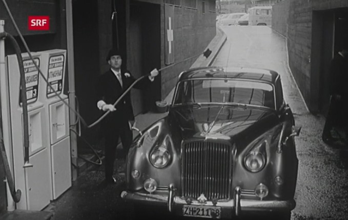 Ein Mann wäscht sein Auto in der Waschanlage