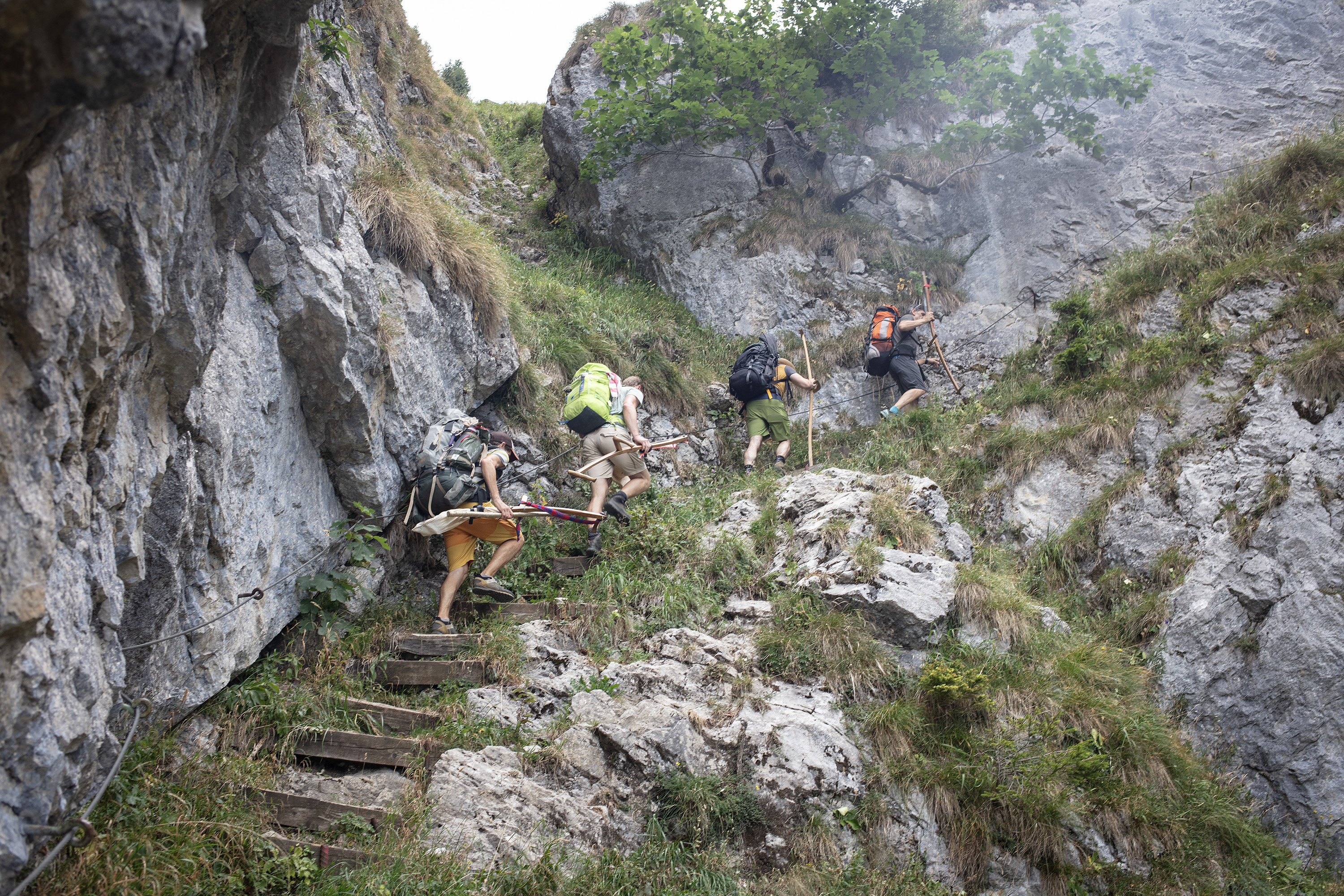 Vier Männer steigen einen steilen Bergpfad hinauf