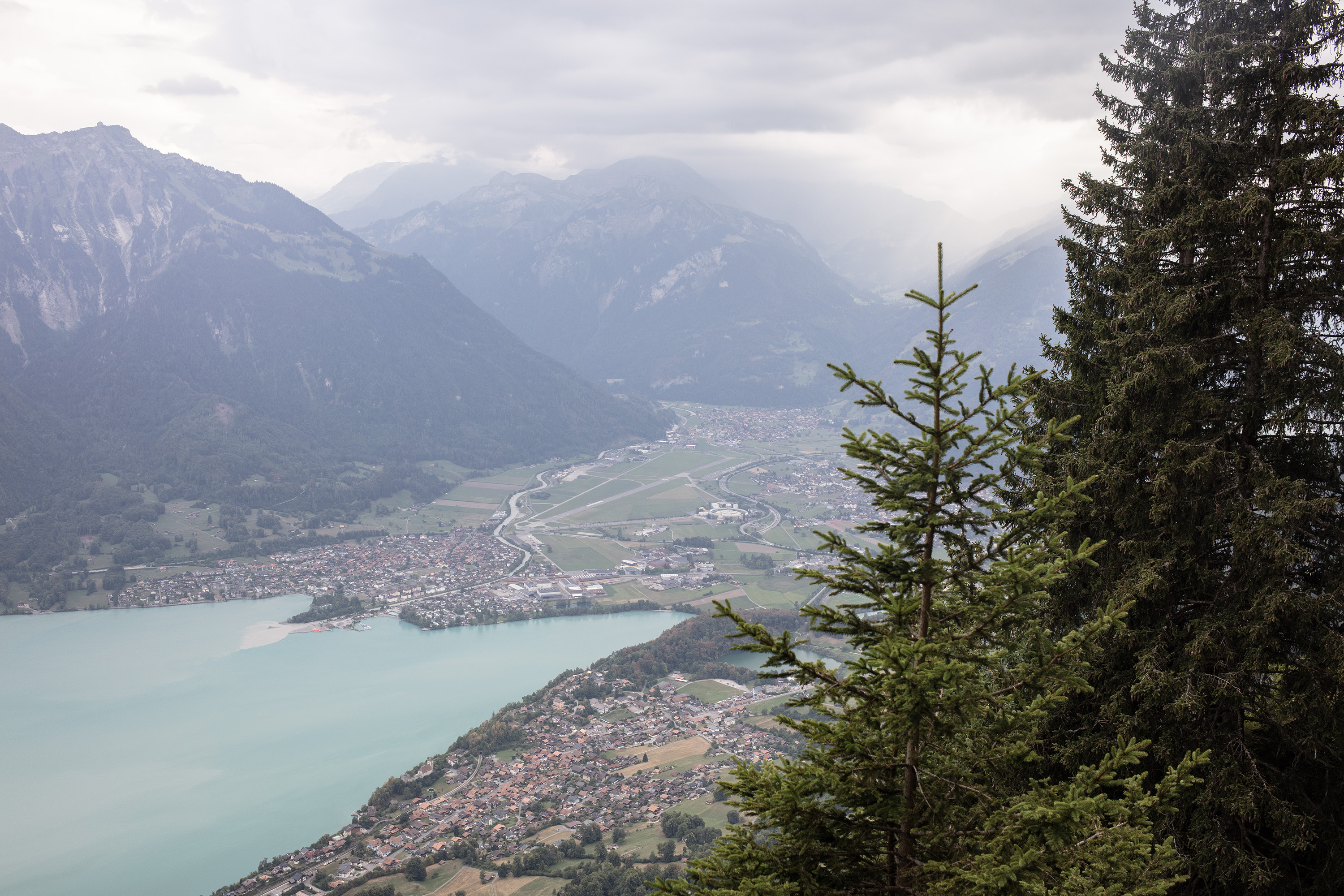 Ein Blick auf einen See und eine Kleinstadt, im Hintergrund erheben sich Berge