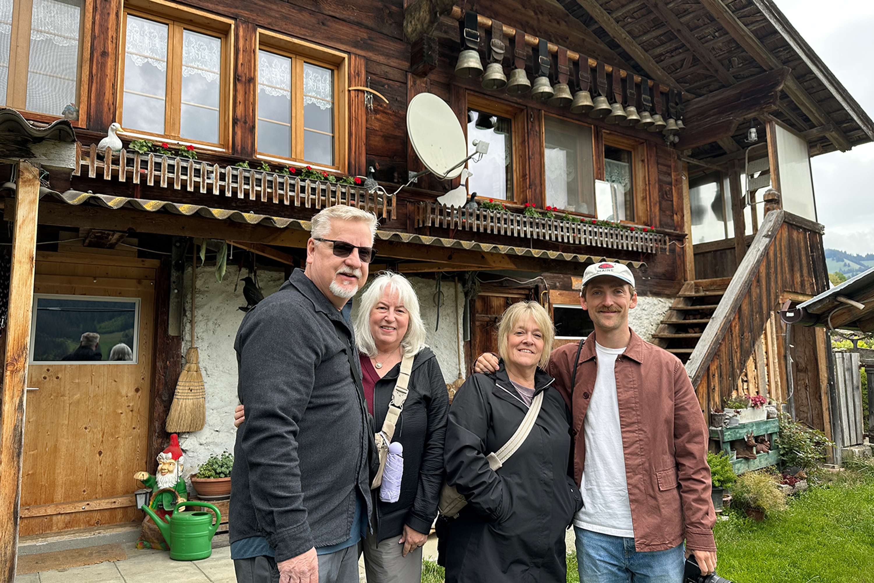 Four people in front of a chalet