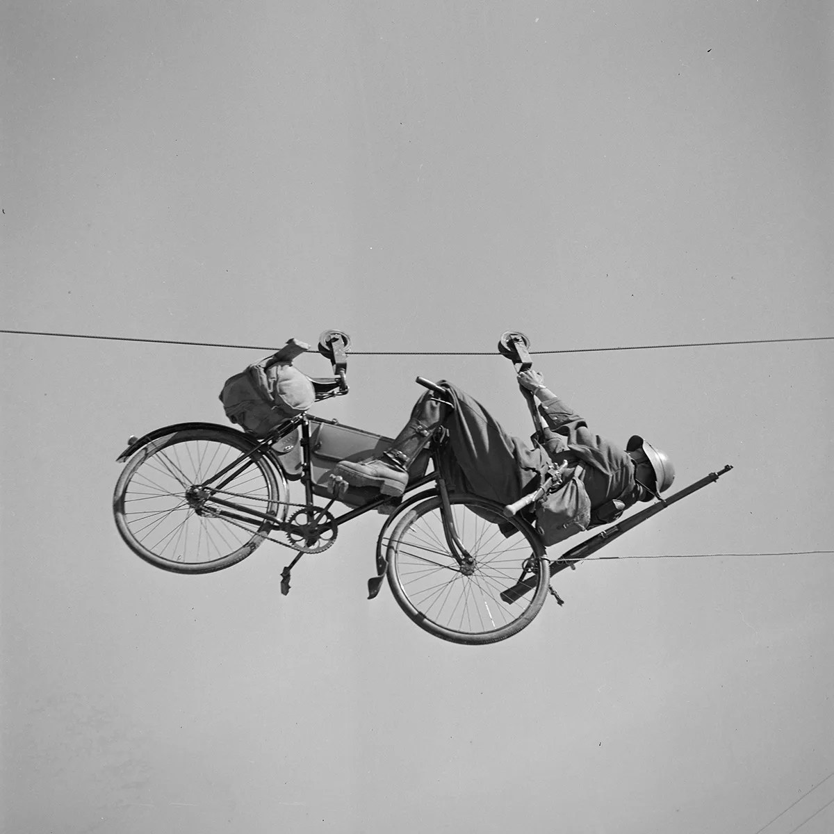 Ein Velofahrer und sein Velo auf einer Seilbahn. Foto von Karl Egli, um 1935.