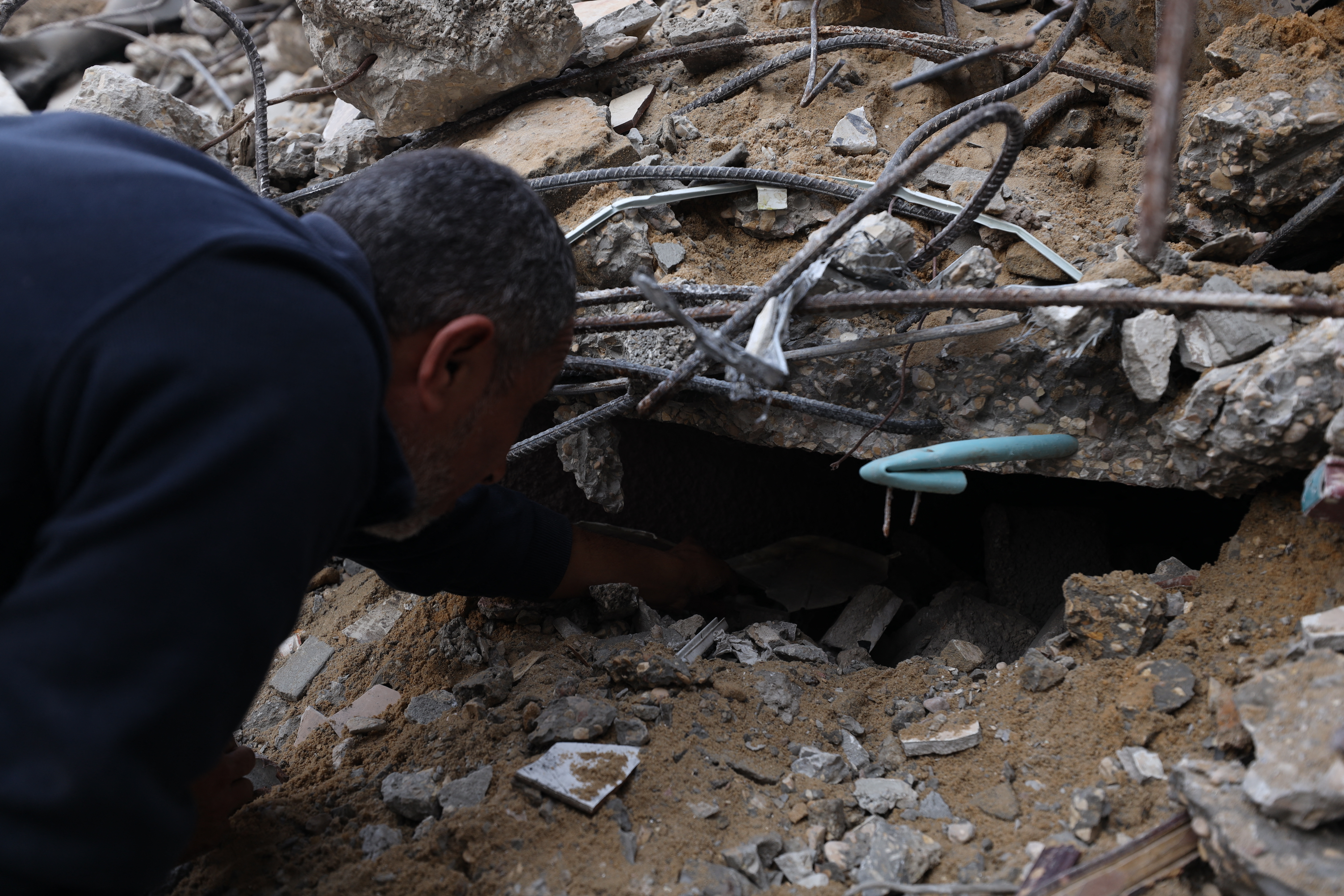 Palestinian civil defense teams carry out search and recovery operations with heavy machinery at the site of a building destroyed during Israeli attacks in the Sheikh Radwan neighborhood of Gaza City
