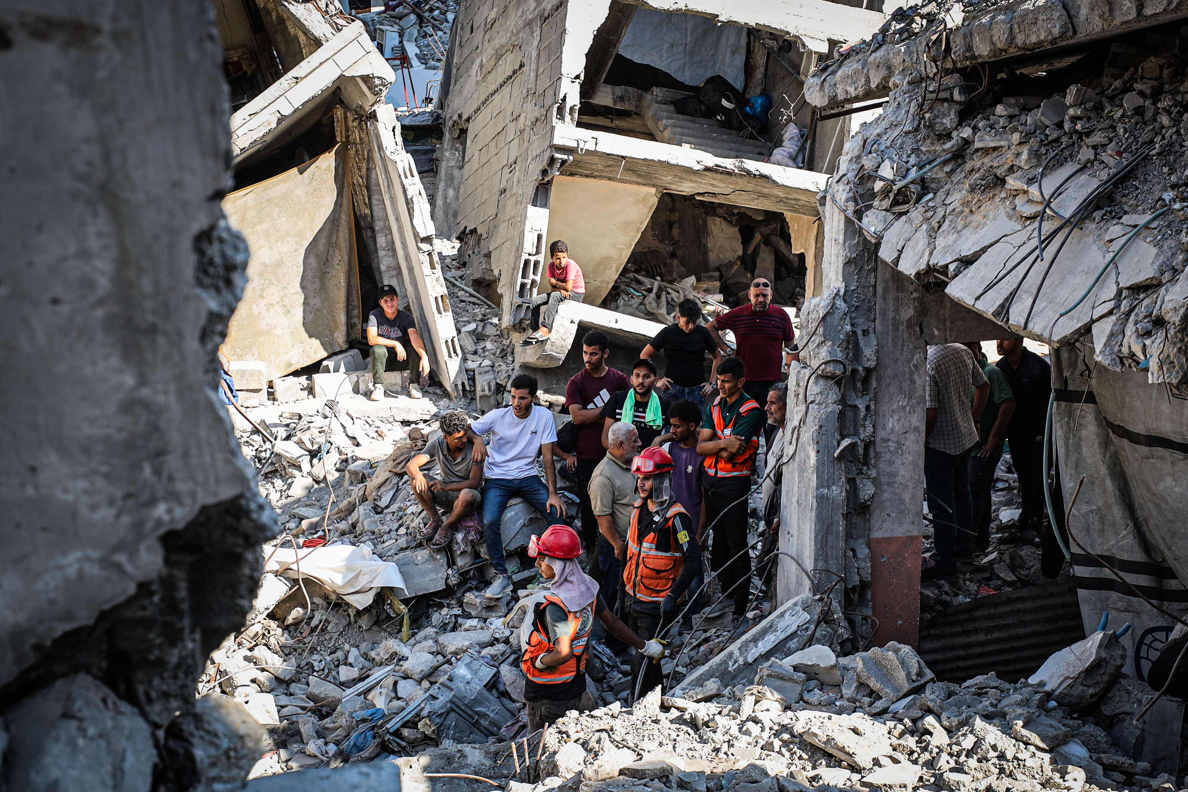 Palestinian Civil Defense teams conduct search and rescue operations among the rubble of a destroyed house belonging to the Sawafiri family
