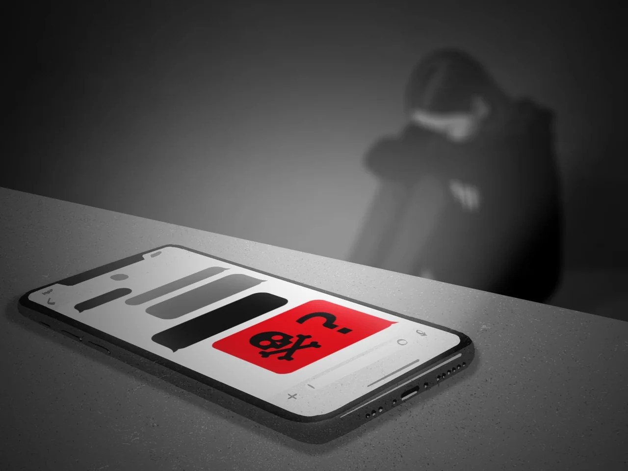 illustrazione: smartphone appoggiato su un tavolo e persona che piange seduta a terra lì vicino