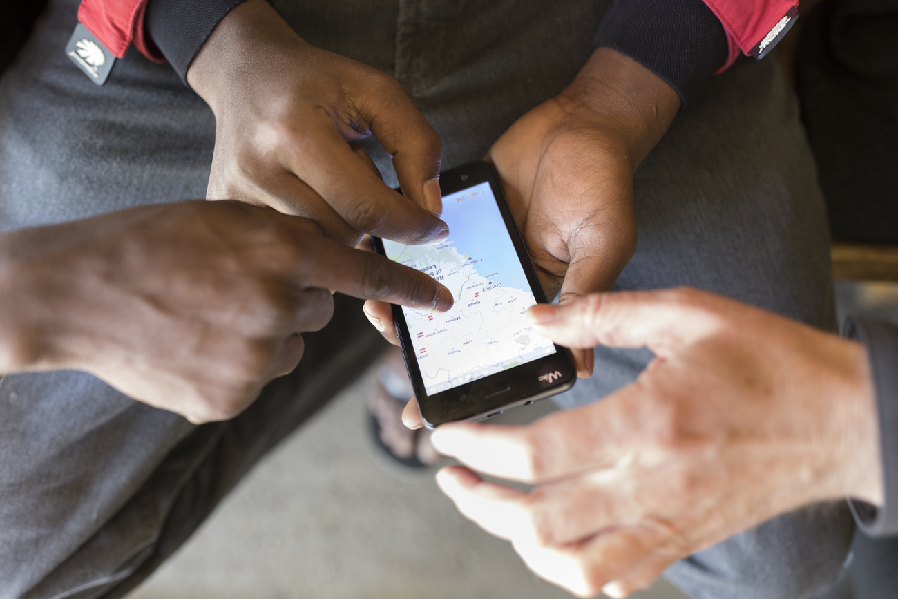 Persone indicano un luogo su una mappa su uno smartphone