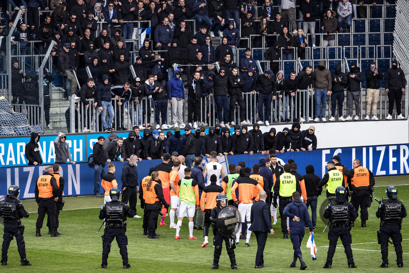 Grasshopper Club Zurich players face GC supporters after a Super League match against FC Lucerne was abandoned in Lucerne on May 12, 2019. Voters in canton Lucerne have now backed new measures aimed at tackling violence surrounding football matches.